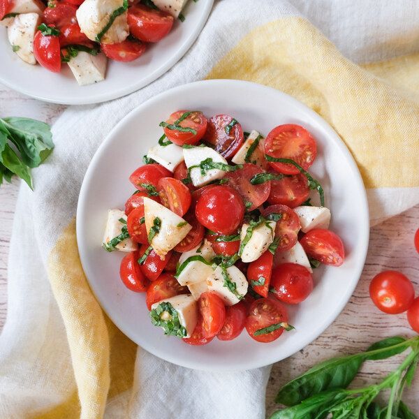 
Sałatka Caprese z świeżą mozzarellą, pomidorami, bazylią i balsamicznym octem.